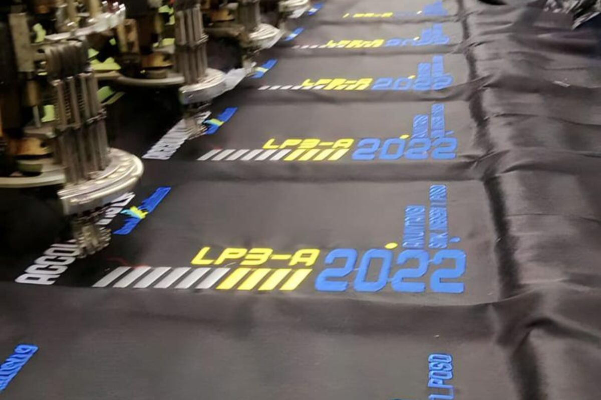 Embroidery machine stitching a logo onto fabric