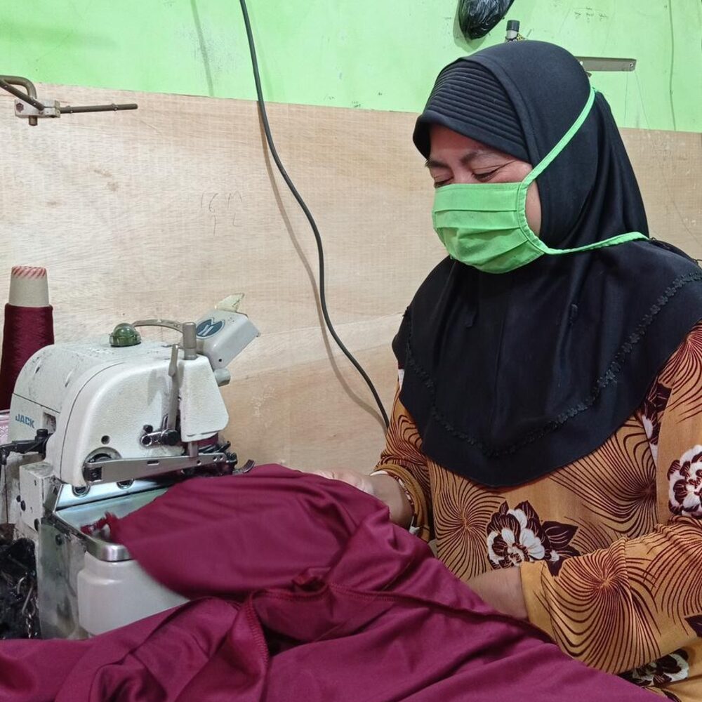 Tailor sewing garments at a machine in the workshop